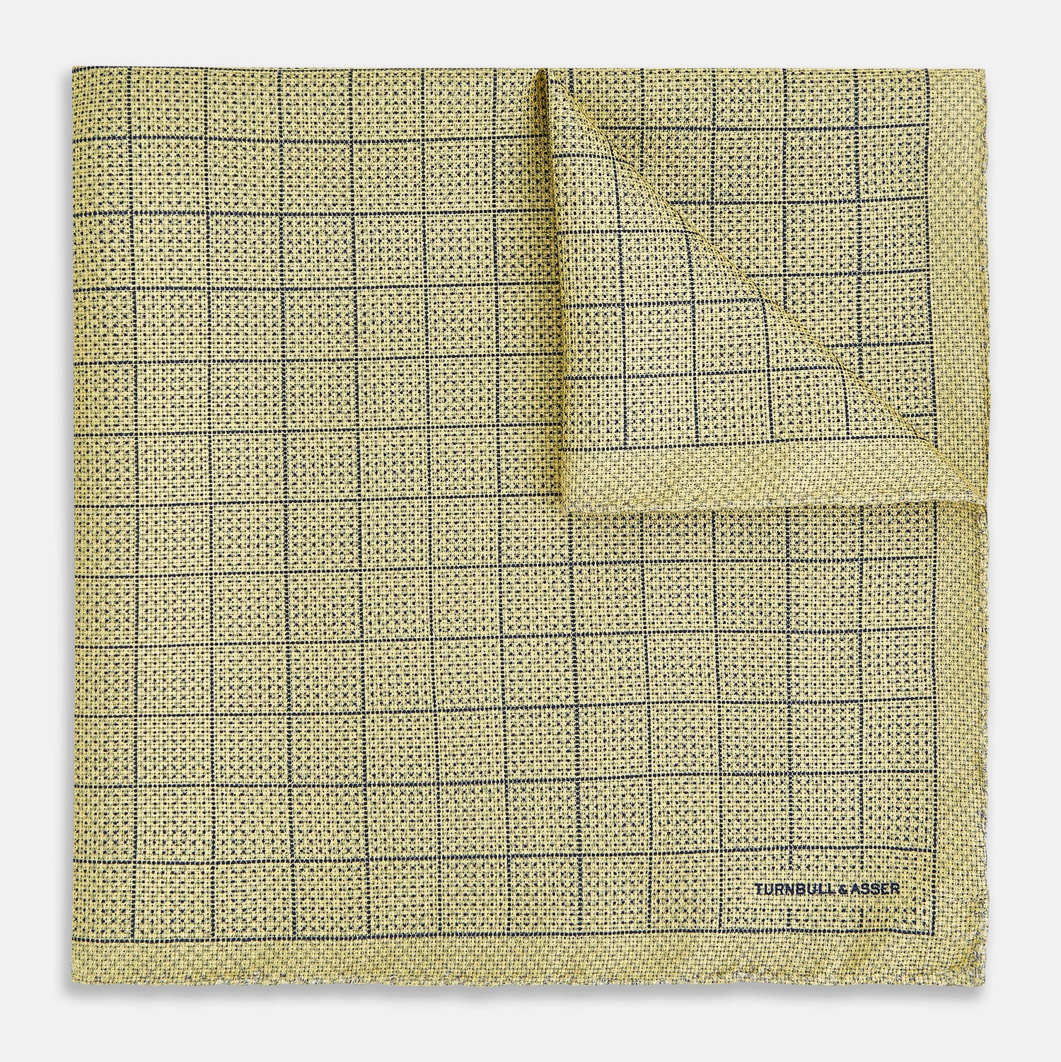 View 1 of product A yellow silk pocket square featuring a small black grid pattern of dotted squares, neatly folded at one corner. "Turnbull & Asser UK" is printed in the bottom right corner.