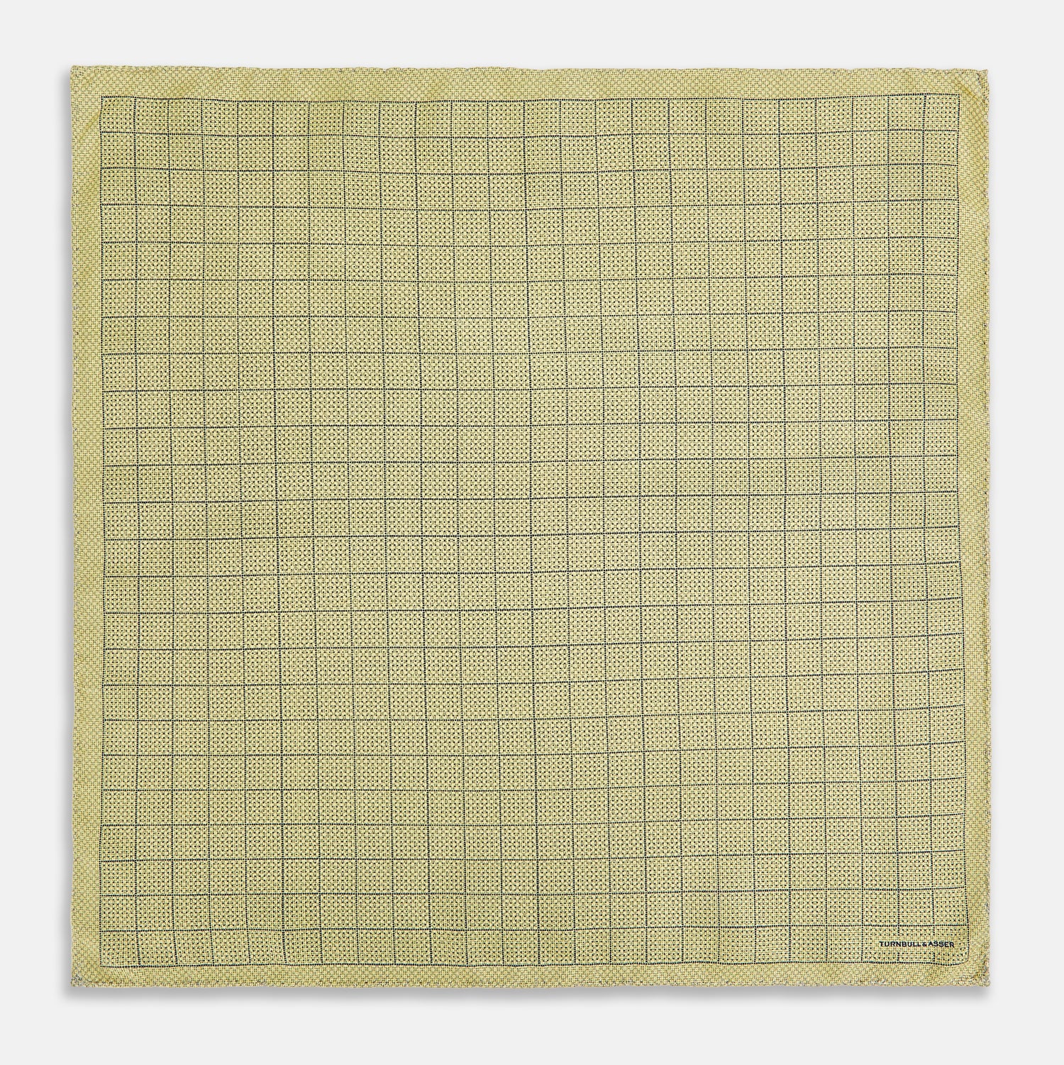 View 4 of product A yellow silk pocket square featuring a small black grid pattern of dotted squares, neatly folded at one corner. "Turnbull & Asser UK" is printed in the bottom right corner.