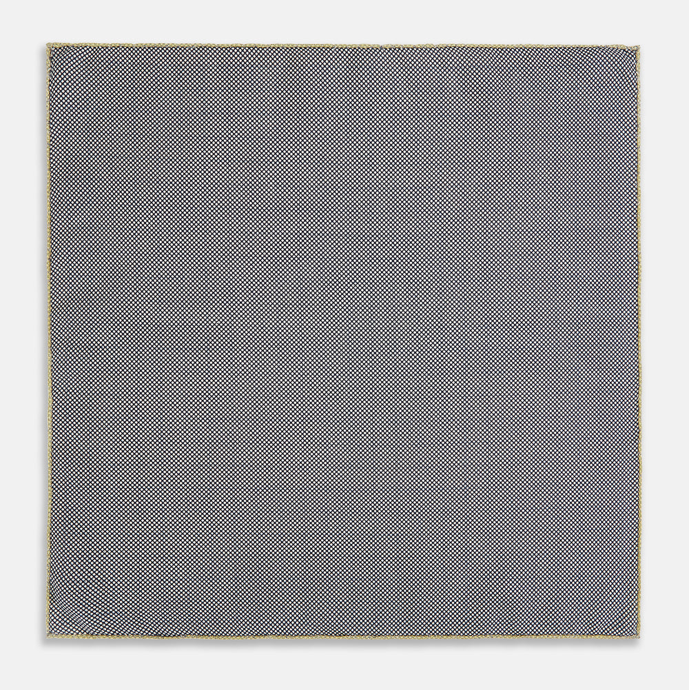 A yellow silk pocket square featuring a small black grid pattern of dotted squares, neatly folded at one corner. "Turnbull & Asser UK" is printed in the bottom right corner.
