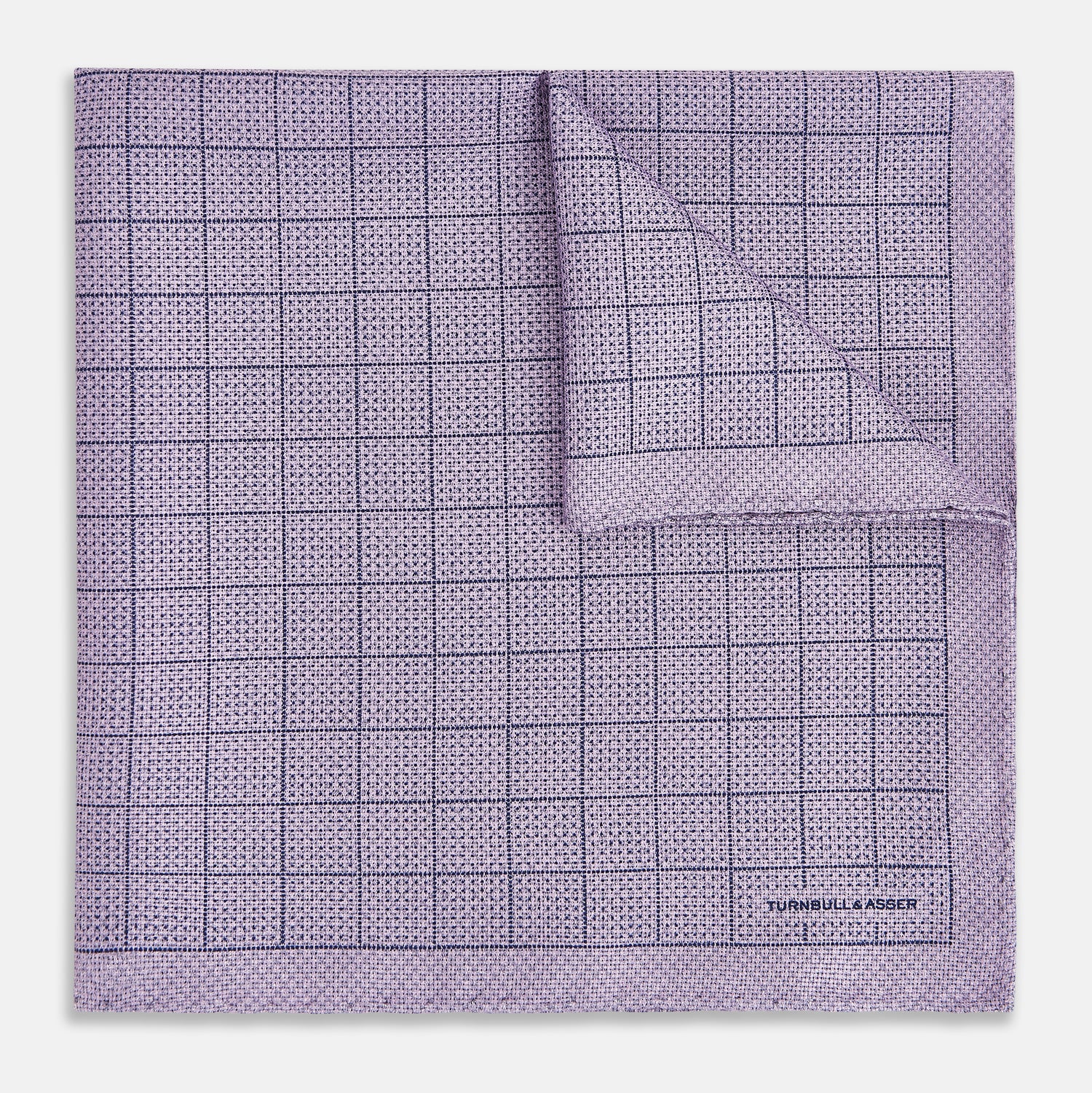 View 2 of product The Checked Lilac Pocket Square in Silk by Turnbull & Asser UK features a grid pattern in purple with a solid border, neatly folded to display its double-sided design and contrasting black and white dotted squares on the reverse side.