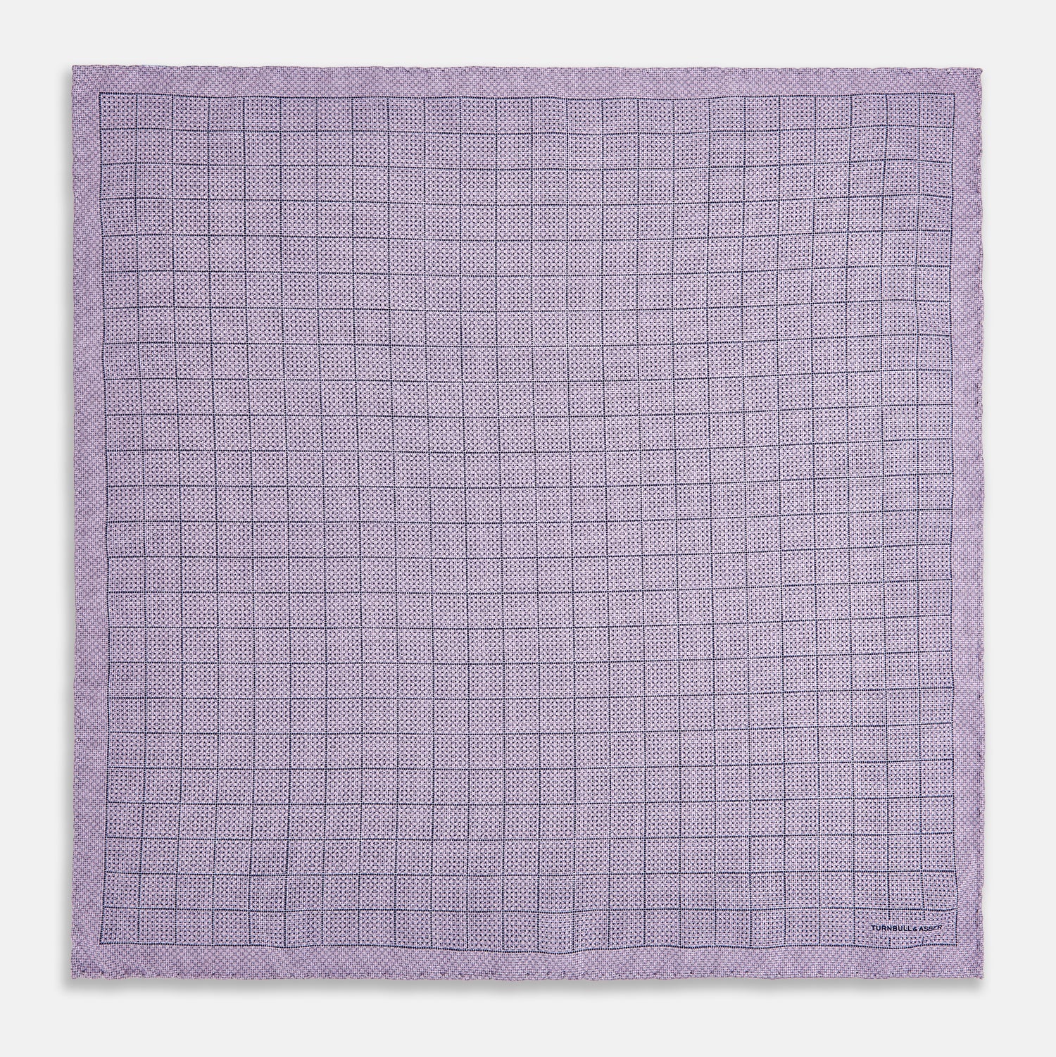 View 5 of product The Checked Lilac Pocket Square in Silk by Turnbull & Asser UK features a grid pattern in purple with a solid border, neatly folded to display its double-sided design and contrasting black and white dotted squares on the reverse side.
