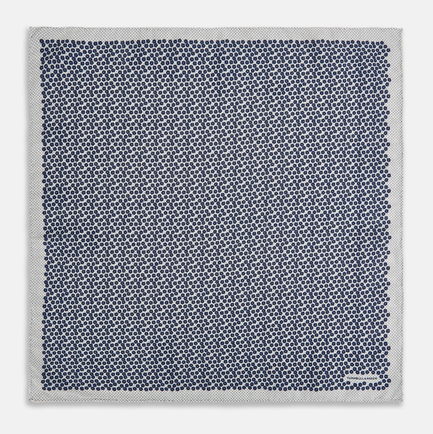 View 5 of product A square silk pocket square from Turnbull & Asser UK, featuring a subtle floral grey pattern; one corner is folded to reveal its double-sided design with a complementary pattern on the reverse side.