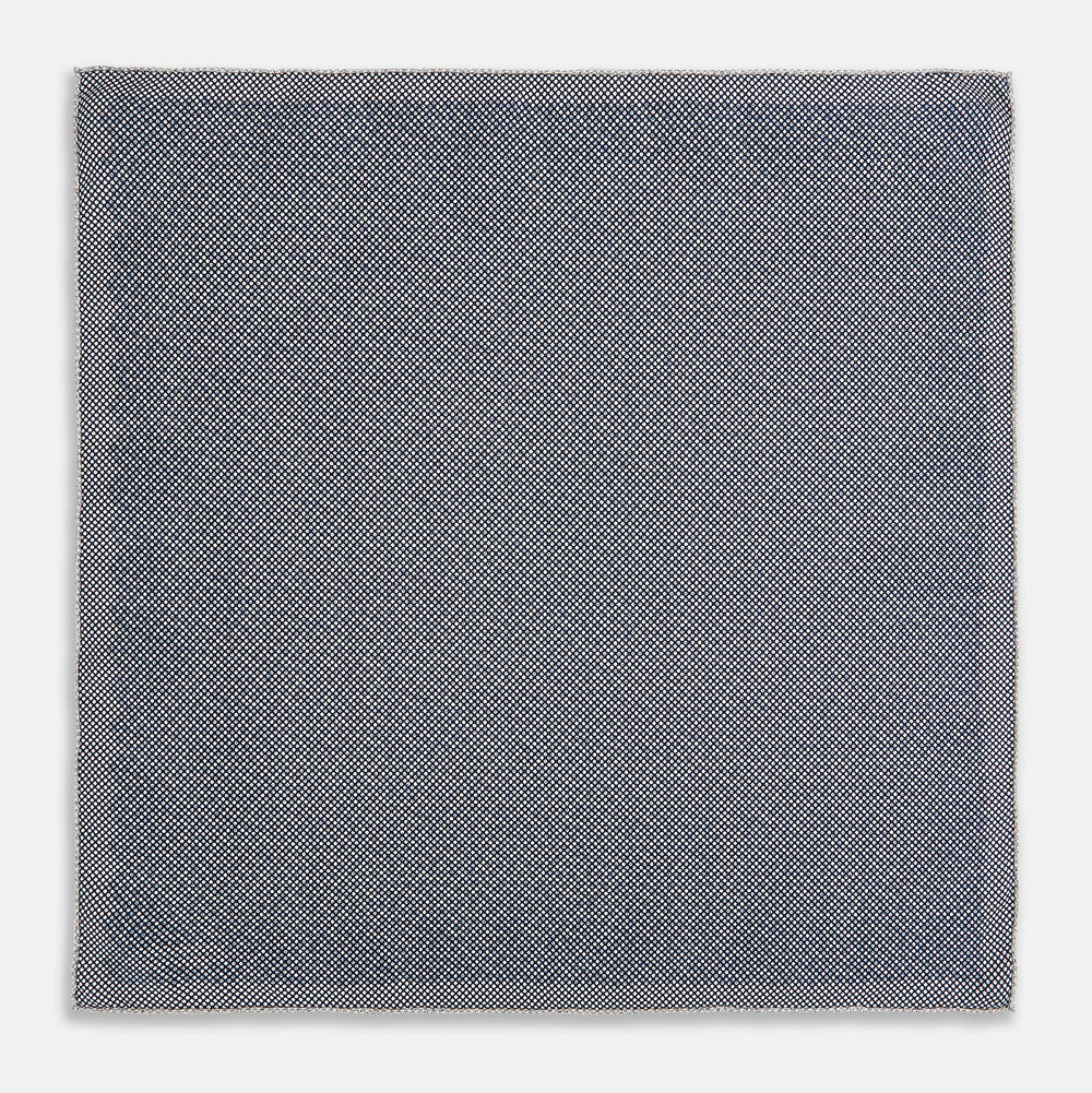 A square silk pocket square from Turnbull & Asser UK, featuring a subtle floral grey pattern; one corner is folded to reveal its double-sided design with a complementary pattern on the reverse side.