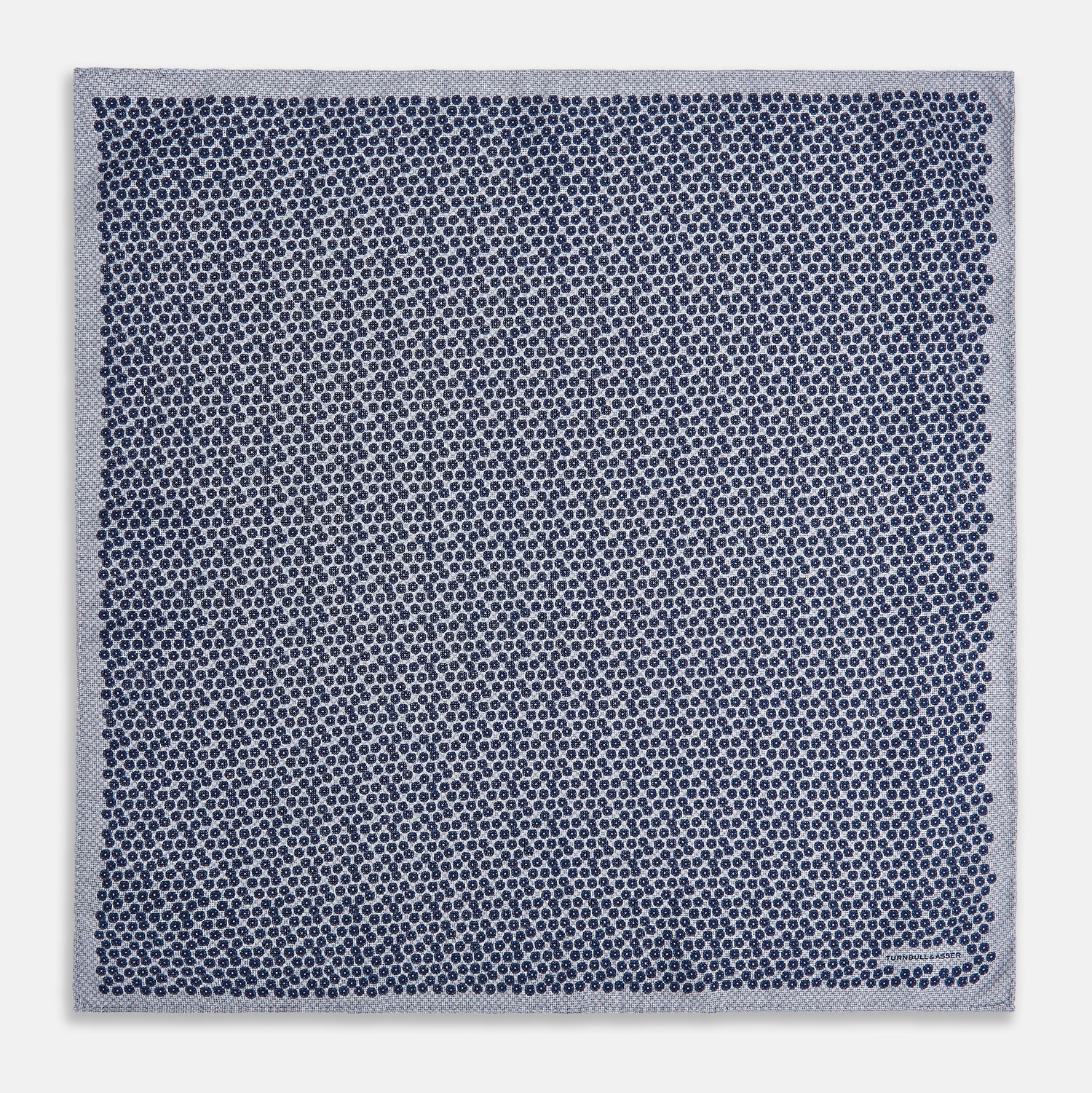 View 5 of product The Turnbull & Asser UK Floral Blue Pocket Square in Silk showcases a refined double-sided design, with a clustered dot pattern in blue and white on the front and a delicate fine dotted motif on the back. Presented with one corner elegantly folded, it exudes sophisticated style.