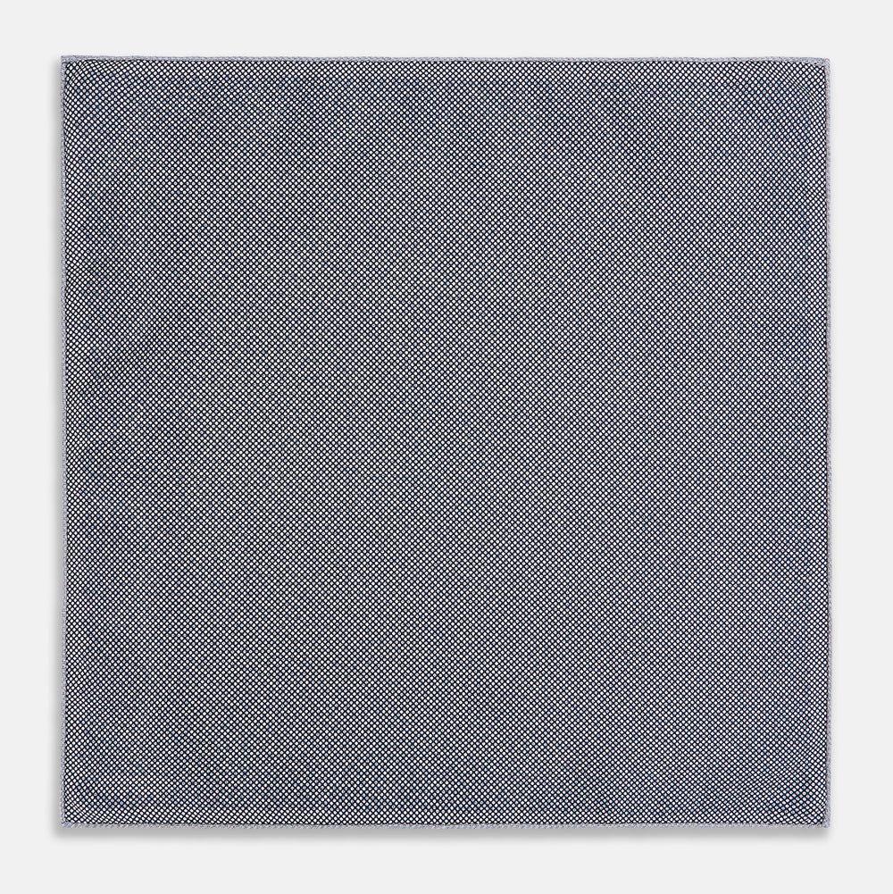 The Turnbull & Asser UK Floral Blue Pocket Square in Silk showcases a refined double-sided design, with a clustered dot pattern in blue and white on the front and a delicate fine dotted motif on the back. Presented with one corner elegantly folded, it exudes sophisticated style.