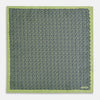 View 5 of product The Turnbull & Asser UK Floral Green Pocket Square in Silk is a square accessory featuring a blue floral pattern with a green border, partly folded at one corner to showcase its double-sided design, revealing a navy and light green dotted pattern on the reverse.