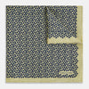 View 1 of product Introducing the Floral Yellow Pocket Square in Silk by Turnbull & Asser UK—a sophisticated square accessory featuring a vibrant yellow border and a black-and-white geometric dot pattern. One corner is tastefully folded to reveal its double-sided design, showcasing a smaller, denser dot motif on the reverse. Perfect for adding a modern touch of flair to any outfit or setting.