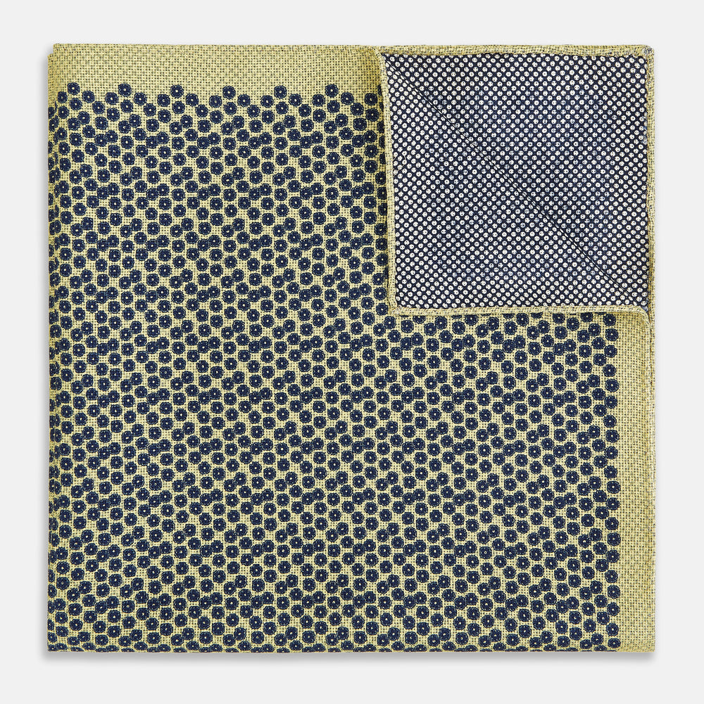Introducing the Floral Yellow Pocket Square in Silk by Turnbull & Asser UK—a sophisticated square accessory featuring a vibrant yellow border and a black-and-white geometric dot pattern. One corner is tastefully folded to reveal its double-sided design, showcasing a smaller, denser dot motif on the reverse. Perfect for adding a modern touch of flair to any outfit or setting.