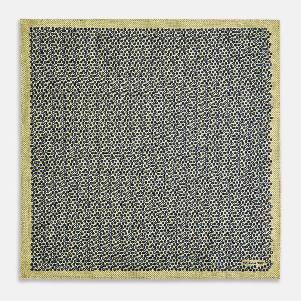 Introducing the Floral Yellow Pocket Square in Silk by Turnbull & Asser UK—a sophisticated square accessory featuring a vibrant yellow border and a black-and-white geometric dot pattern. One corner is tastefully folded to reveal its double-sided design, showcasing a smaller, denser dot motif on the reverse. Perfect for adding a modern touch of flair to any outfit or setting.