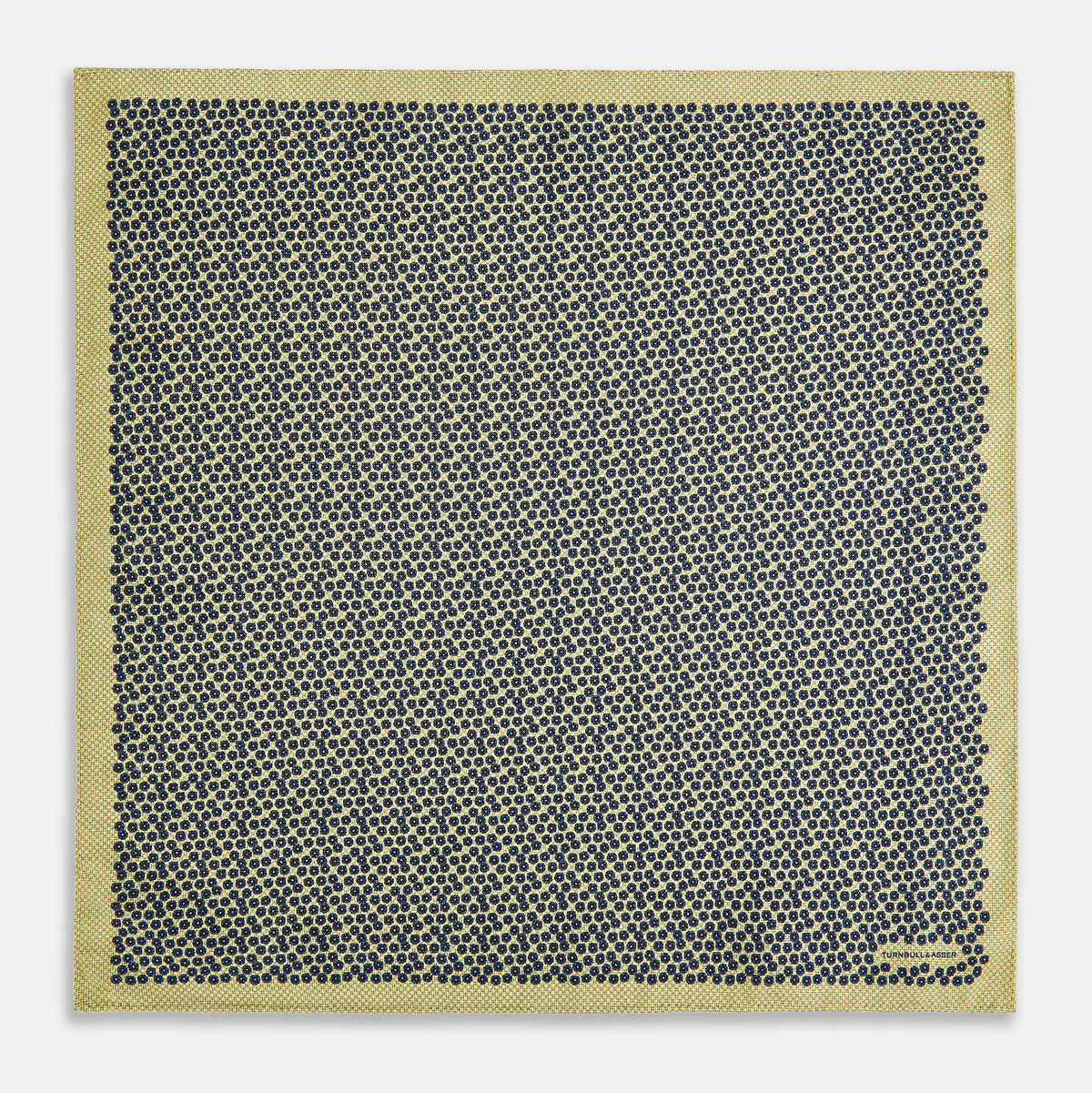 View 5 of product Introducing the Floral Yellow Pocket Square in Silk by Turnbull & Asser UK—a sophisticated square accessory featuring a vibrant yellow border and a black-and-white geometric dot pattern. One corner is tastefully folded to reveal its double-sided design, showcasing a smaller, denser dot motif on the reverse. Perfect for adding a modern touch of flair to any outfit or setting.