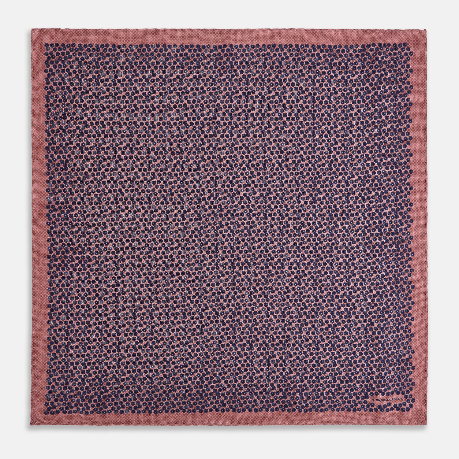 View 5 of product The Floral Pink Pocket Square in Silk by Turnbull & Asser UK showcases a refined pattern with a pink floral design and a contrasting border. The top right corner is elegantly folded to reveal the reverse side’s complementary blue and white dotted motif, emphasizing its double-sided versatility.