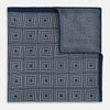 View 4 of product Introducing the Geometric Navy Tile Pocket Square in Silk by Turnbull & Asser UK—a folded navy and white accessory showcasing a double-sided design, with one side featuring concentric squares that form a striking geometric pattern and the other adorned with an elegant small dot motif.