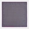 View 6 of product The Turnbull & Asser UK Geometric Purple Tile Pocket Square in Silk features a vibrant purple hue adorned with concentric square motifs. One corner is folded to reveal its double-sided design, showcasing a contrasting black-and-white dotted underside.