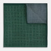 View 4 of product The Geometric Green Tile Pocket Square in Silk by Turnbull & Asser UK features a sophisticated tonal green design with a subtle pattern of concentric squares. One corner is folded to highlight the elegant double-sided construction, revealing a contrasting black and white small dot pattern on the reverse.