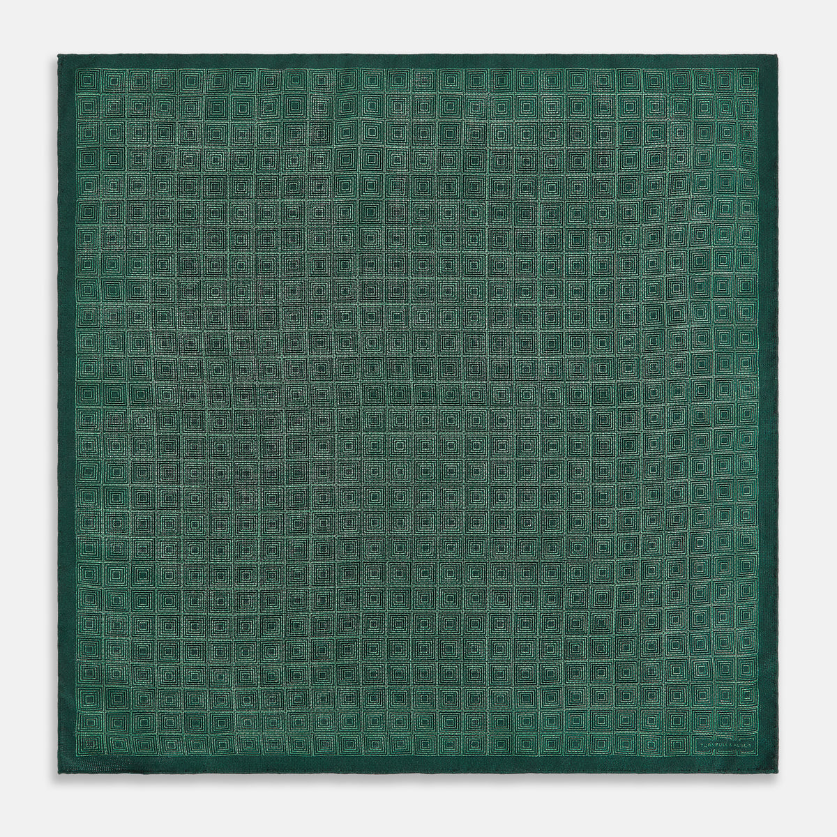 View 5 of product The Geometric Green Tile Pocket Square in Silk by Turnbull & Asser UK features a sophisticated tonal green design with a subtle pattern of concentric squares. One corner is folded to highlight the elegant double-sided construction, revealing a contrasting black and white small dot pattern on the reverse.