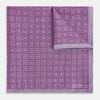 View 2 of product Certainly! Here’s a rewritten version of your sentence, incorporating the product data: The Geometric Lilac Tile Pocket Square in Silk by Turnbull & Asser UK features a lilac purple geometric pattern with a subtle square design, partially folded to reveal its double-sided construction with a contrasting black and white dotted pattern on the reverse.