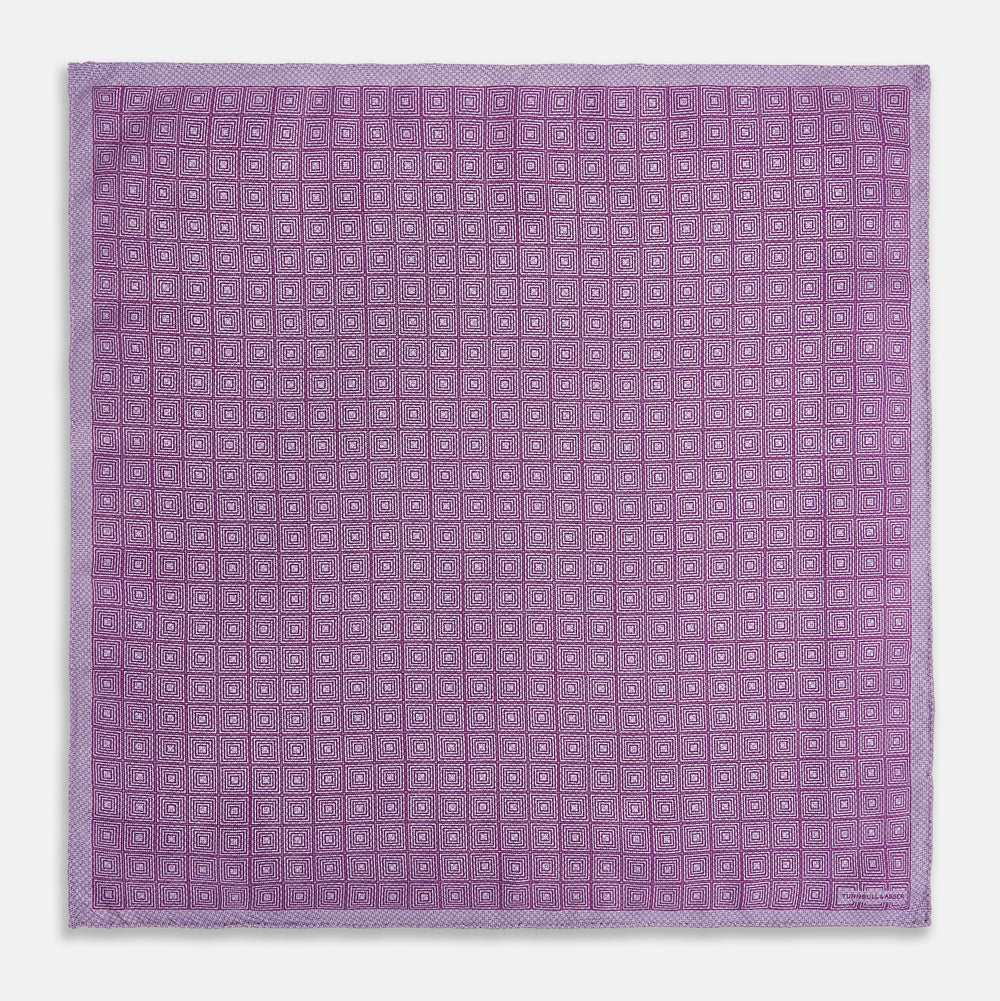 Certainly! Here’s a rewritten version of your sentence, incorporating the product data: The Geometric Lilac Tile Pocket Square in Silk by Turnbull & Asser UK features a lilac purple geometric pattern with a subtle square design, partially folded to reveal its double-sided construction with a contrasting black and white dotted pattern on the reverse.