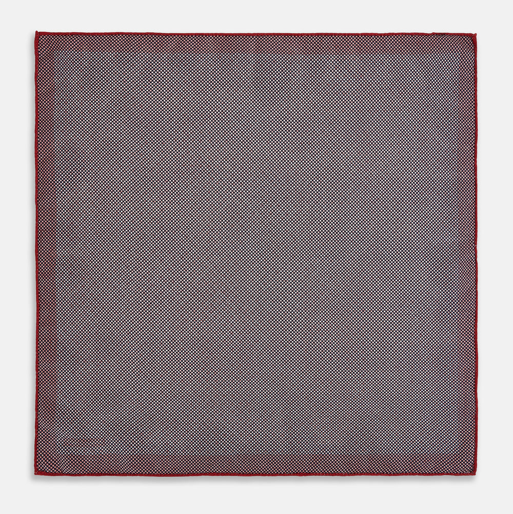Turnbull & Asser UK’s Geometric Red Pocket Square in Silk features a small white checkered pattern and a cleverly flipped corner to showcase its contrasting black and white micro-dot reverse design.