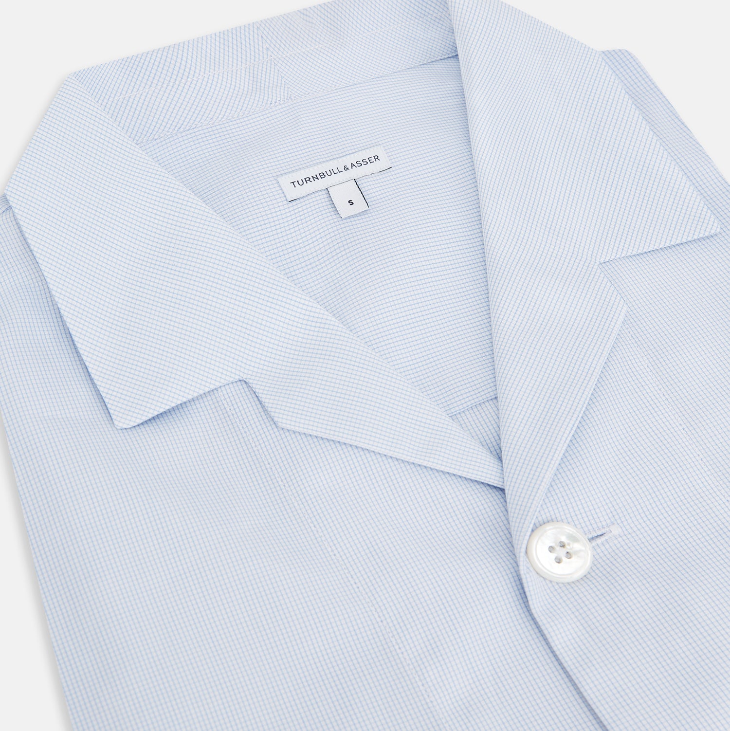 View 2 of product The Turnbull & Asser Pale Blue Fine Micro Check Pyjama Shirt features long sleeves, a notched collar, and a chest pocket—styled flat on white, ideal for elegant nightwear.