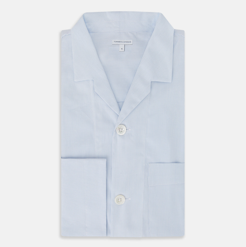 The Turnbull & Asser Pale Blue Fine Micro Check Pyjama Shirt features long sleeves, a notched collar, and a chest pocket—styled flat on white, ideal for elegant nightwear.