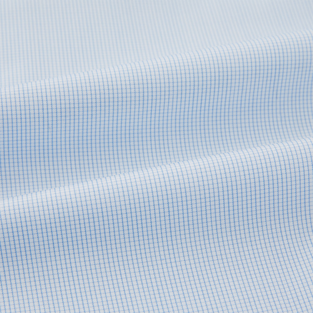 The Turnbull & Asser Pale Blue Fine Micro Check Pyjama Shirt features long sleeves, a notched collar, and a chest pocket—styled flat on white, ideal for elegant nightwear.