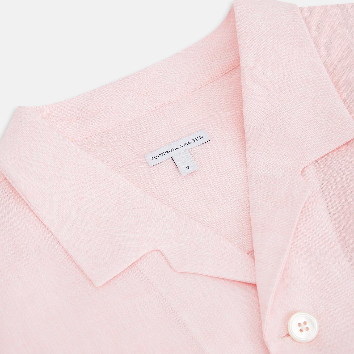 View 2 of product The Turnbull & Asser Pale Pink Linen Pyjama Shirt features long sleeves, a chest pocket, and a classic button-up design—ideal for stylish nightwear or relaxed homewear. Shown laid flat on a white background.