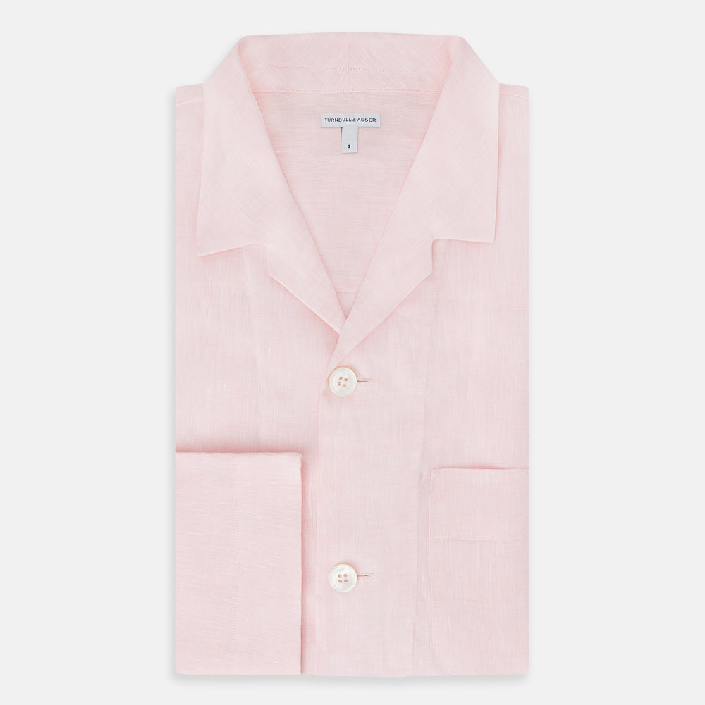 The Turnbull & Asser Pale Pink Linen Pyjama Shirt features long sleeves, a chest pocket, and a classic button-up design—ideal for stylish nightwear or relaxed homewear. Shown laid flat on a white background.