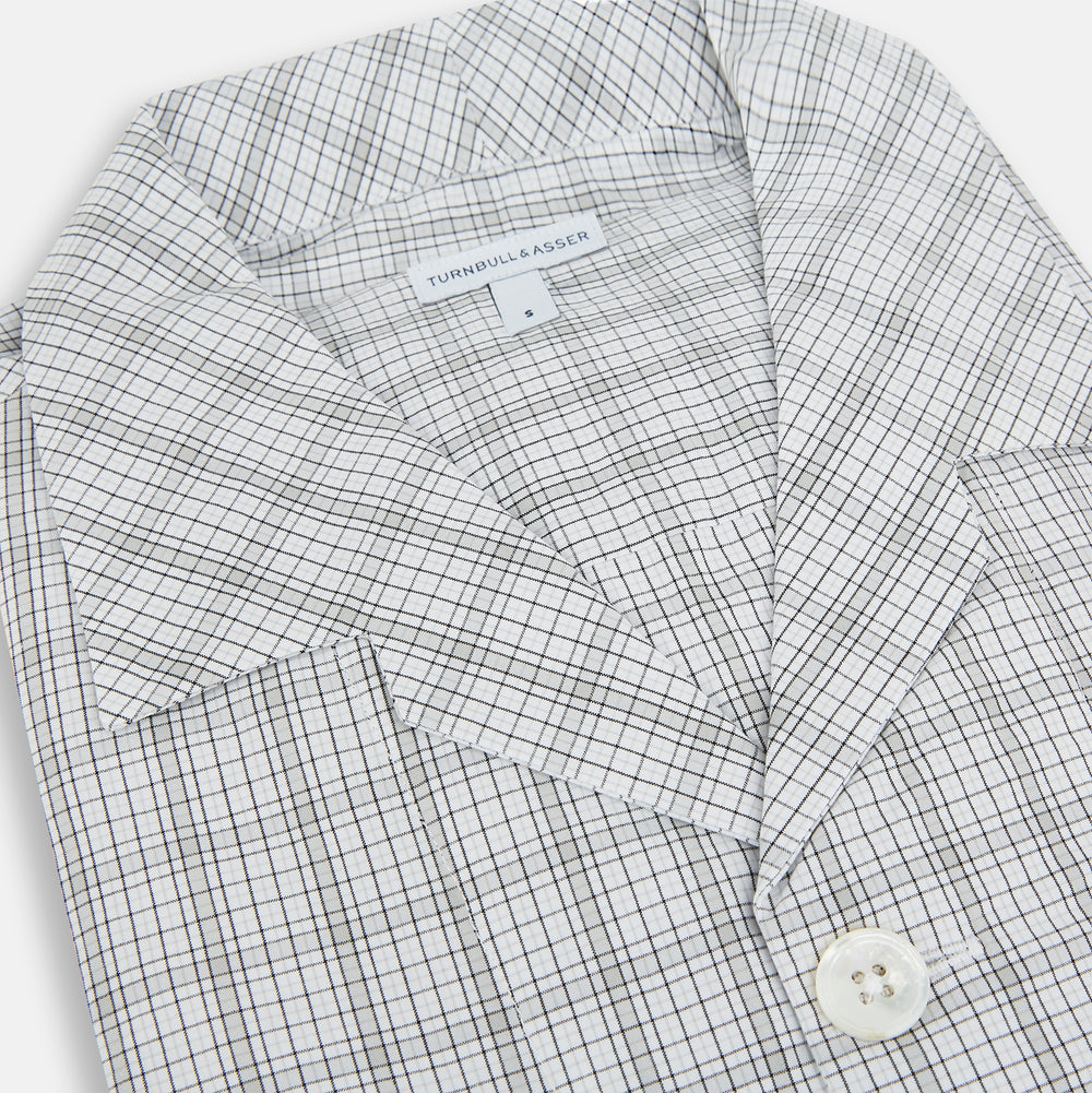 The Turnbull & Asser Grey Fine Multi Graph Check Pyjama Shirt features light grey and white checks, a single chest pocket, and long sleeves—ideal for stylish nightwear or as a classic pyjama shirt. Shown on a white background.
