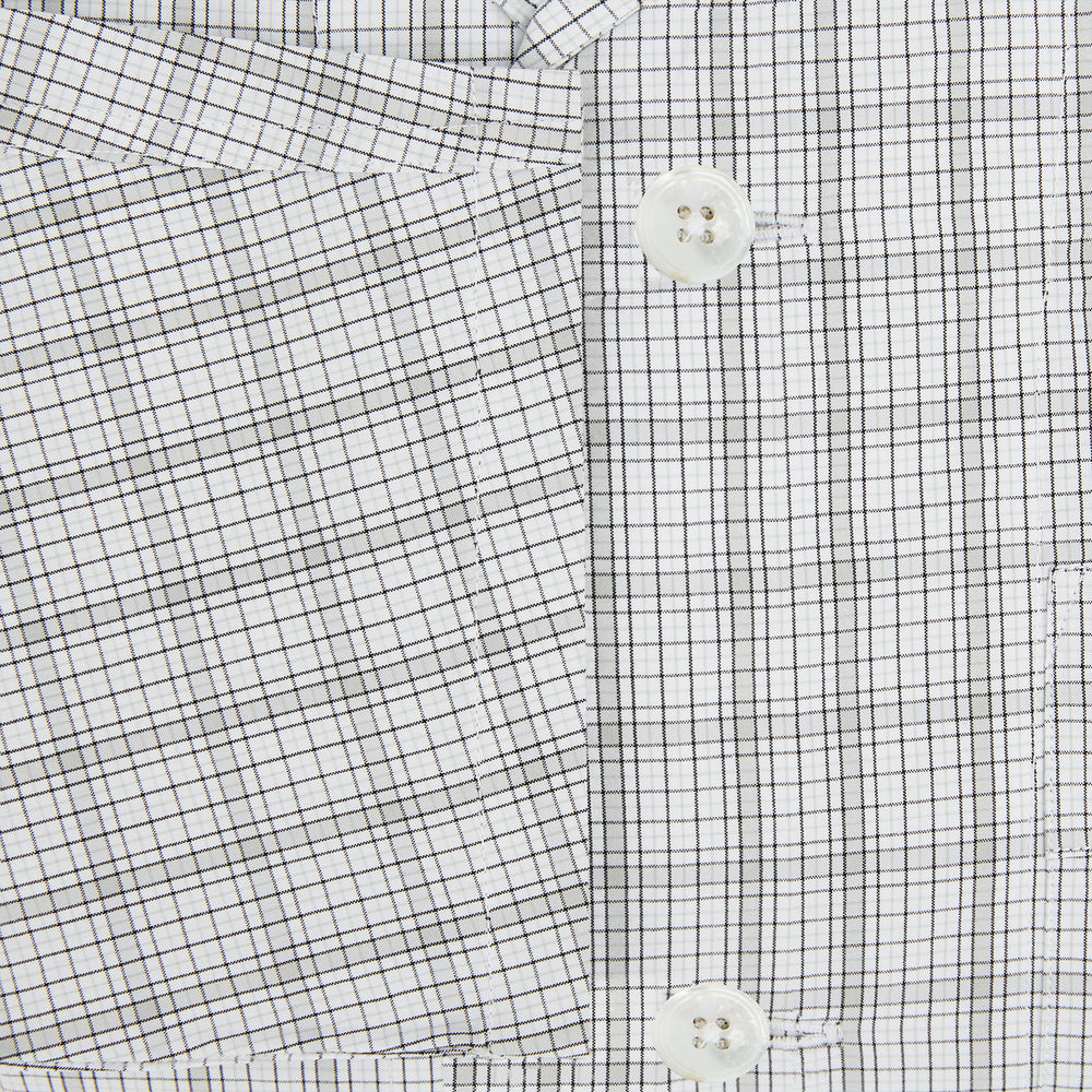 The Turnbull & Asser Grey Fine Multi Graph Check Pyjama Shirt features light grey and white checks, a single chest pocket, and long sleeves—ideal for stylish nightwear or as a classic pyjama shirt. Shown on a white background.