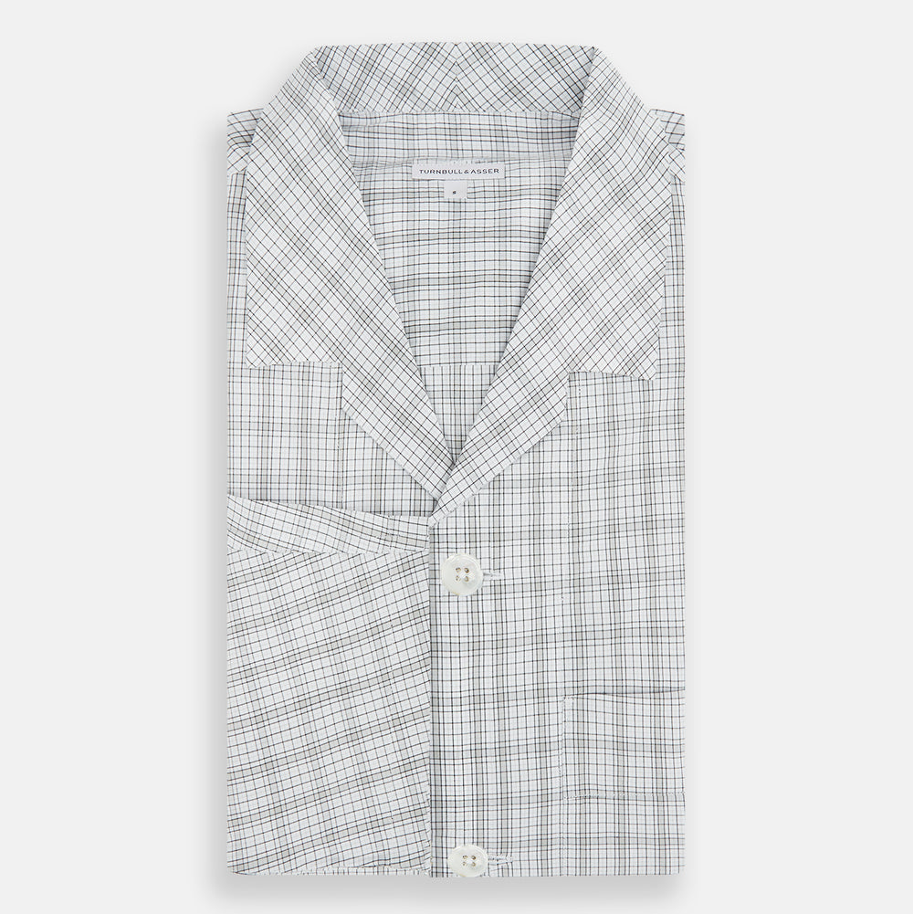 The Turnbull & Asser Grey Fine Multi Graph Check Pyjama Shirt features light grey and white checks, a single chest pocket, and long sleeves—ideal for stylish nightwear or as a classic pyjama shirt. Shown on a white background.