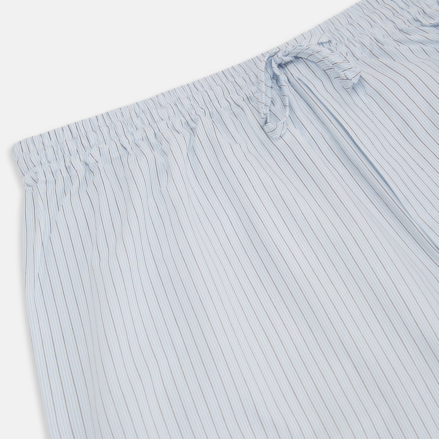 View 2 of product Turnbull & Asser Blue Multi Pinstripe Pyjama Trousers in light blue and white cotton with blue pinstripes, elastic waistband, and drawstring, shown laid flat on a white background.