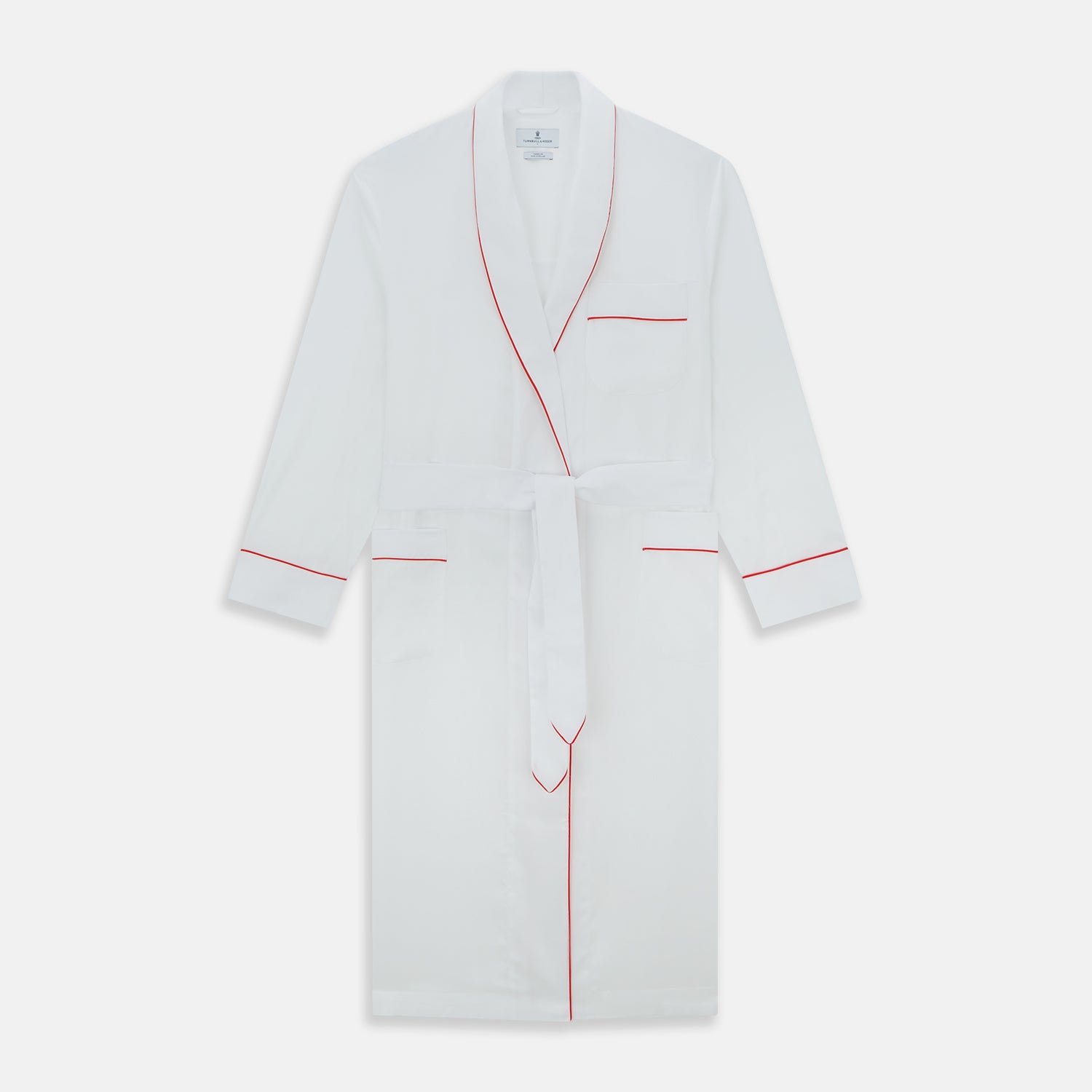 View 1 of product The Turnbull & Asser White Piped Herringbone Cotton Gown features long sleeves, a waist tie, chest pocket, and striking red piping on the collar, cuffs, pocket, and edges—an elegant piece showcased against a white background.