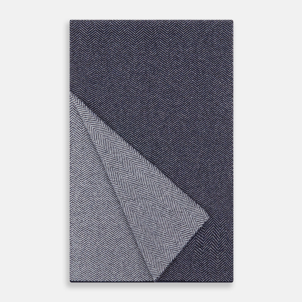 The Turnbull & Asser Reversible Navy and White Herringbone Cashmere Scarf is a timeless winter accessory, featuring an elegant two-tone pattern and luxurious softness.