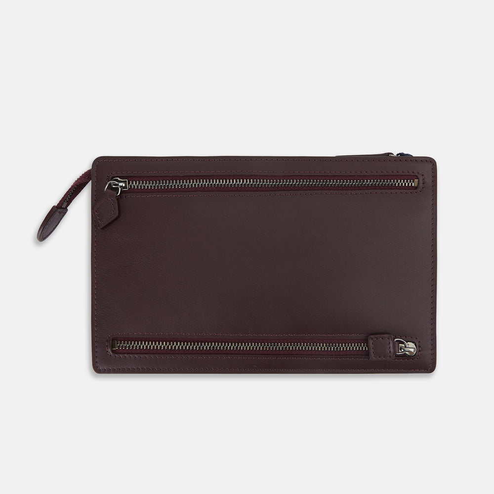 The Turnbull & Asser UK Burgundy Leather Zip Envelope Pouch features two horizontal zipper compartments with matching leather pulls, making it a stylish travel accessory or passport holder.