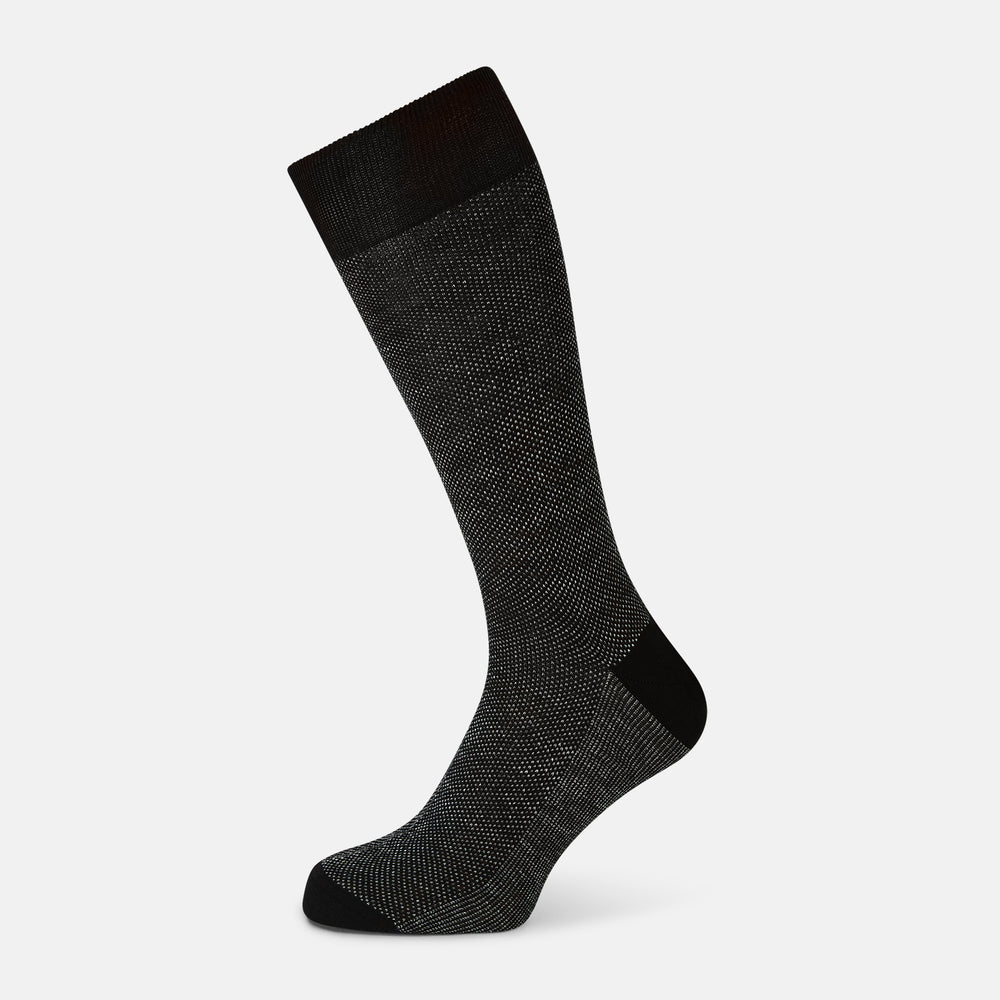 A single Turnbull & Asser UK Charcoal Cotton-Linen Mid-Length Sock, featuring a subtle dotted pattern in black and gray, is displayed against a plain white background.