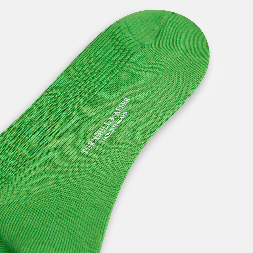 A single Bright Green Mid-Length Merino Sock by Turnbull & Asser is displayed standing with the heel slightly lifted against a plain white background.
