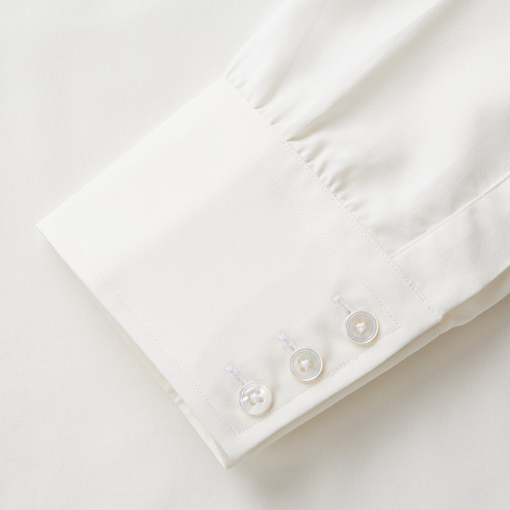 The Turnbull & Asser Cream Silk Mayfair Shirt features long sleeves, a classic collar, button-down front, and buttoned cuffs, shown laid flat on a white background.
