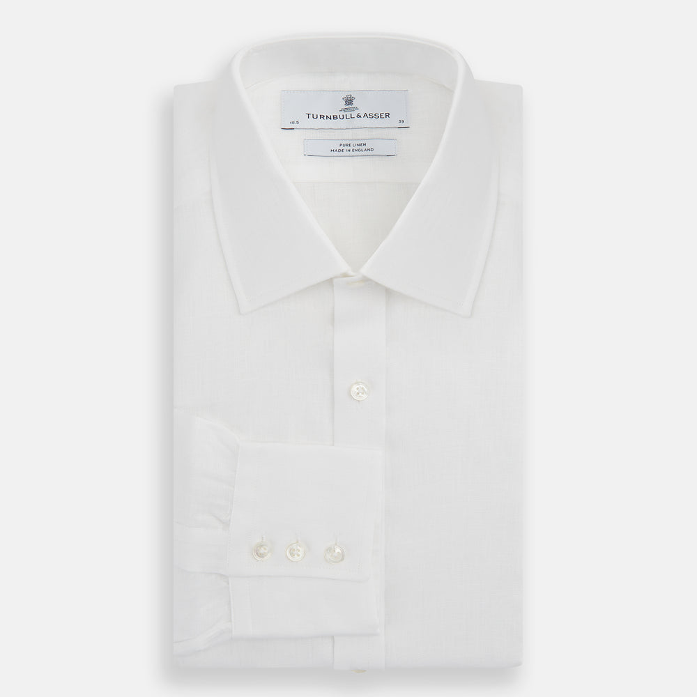 The Turnbull & Asser White Linen Shirt features a T&A collar and 3-button cuffs—an essential summer staple, shown here laid flat on a white background.