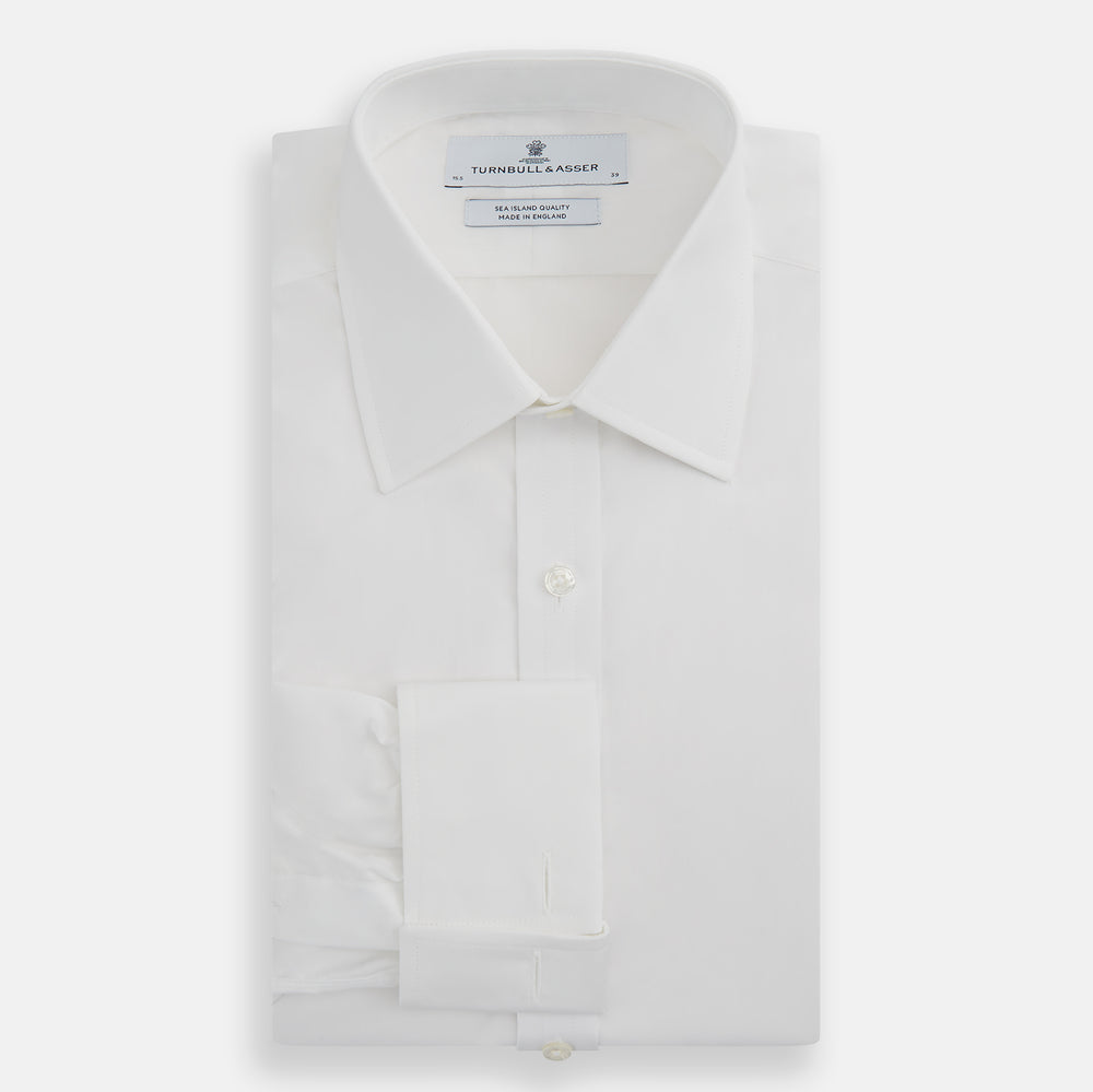 The Turnbull & Asser White Sea Island Quality Cotton Shirt features a T&A collar and double cuffs, crafted from premium cotton and shown laid flat against a white background.