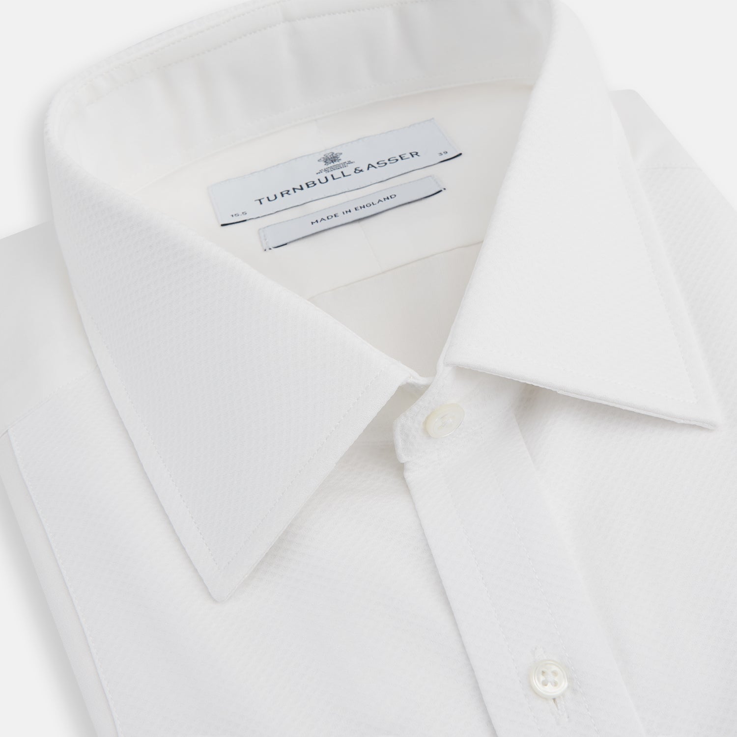 View 2 of product The Turnbull & Asser White Marcella Dress Shirt features a T&A collar, double cuffs, a classic bib front, and a button-down design—ideal for formal occasions. Displayed against a plain white background.