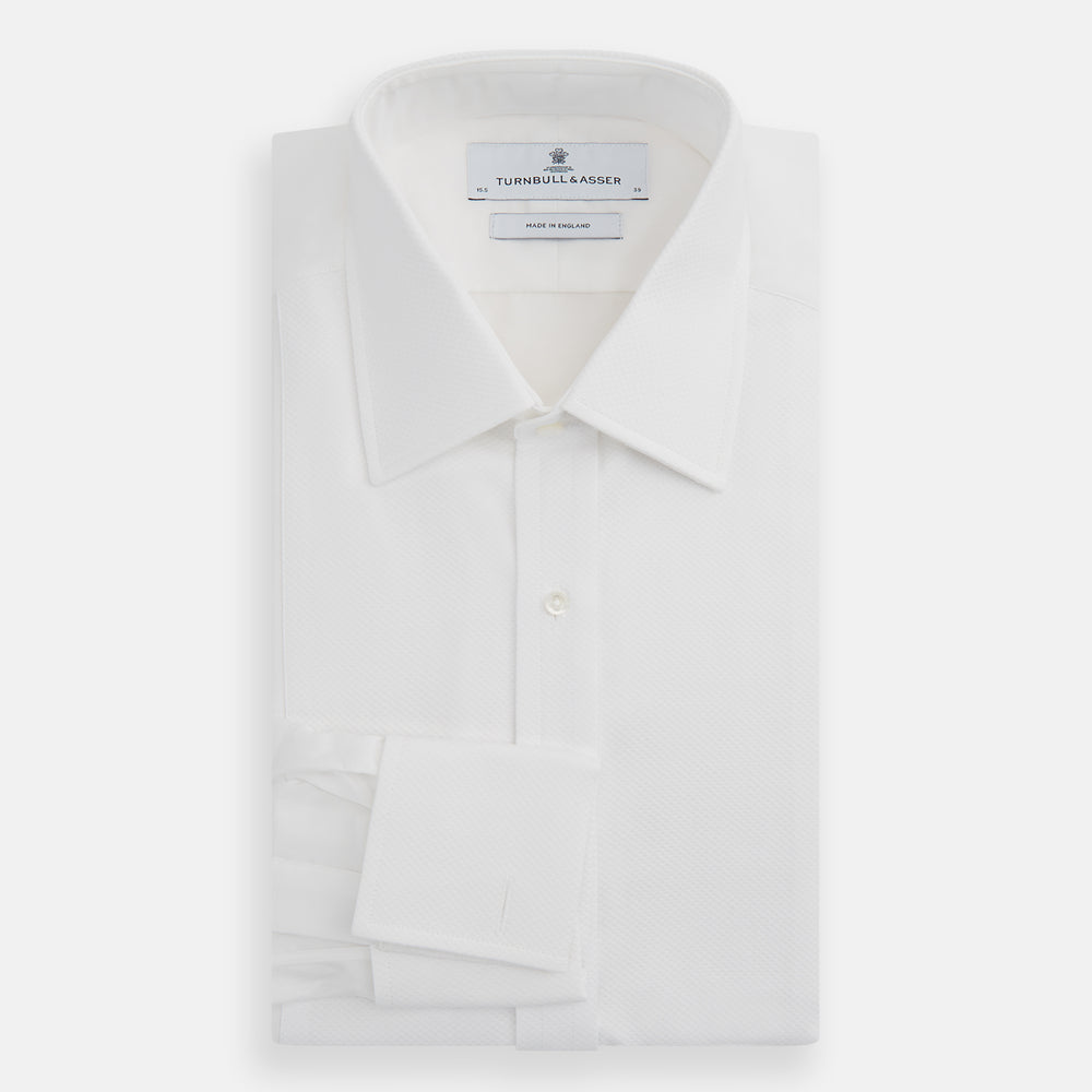 The Turnbull & Asser White Marcella Dress Shirt features a T&A collar, double cuffs, a classic bib front, and a button-down design—ideal for formal occasions. Displayed against a plain white background.