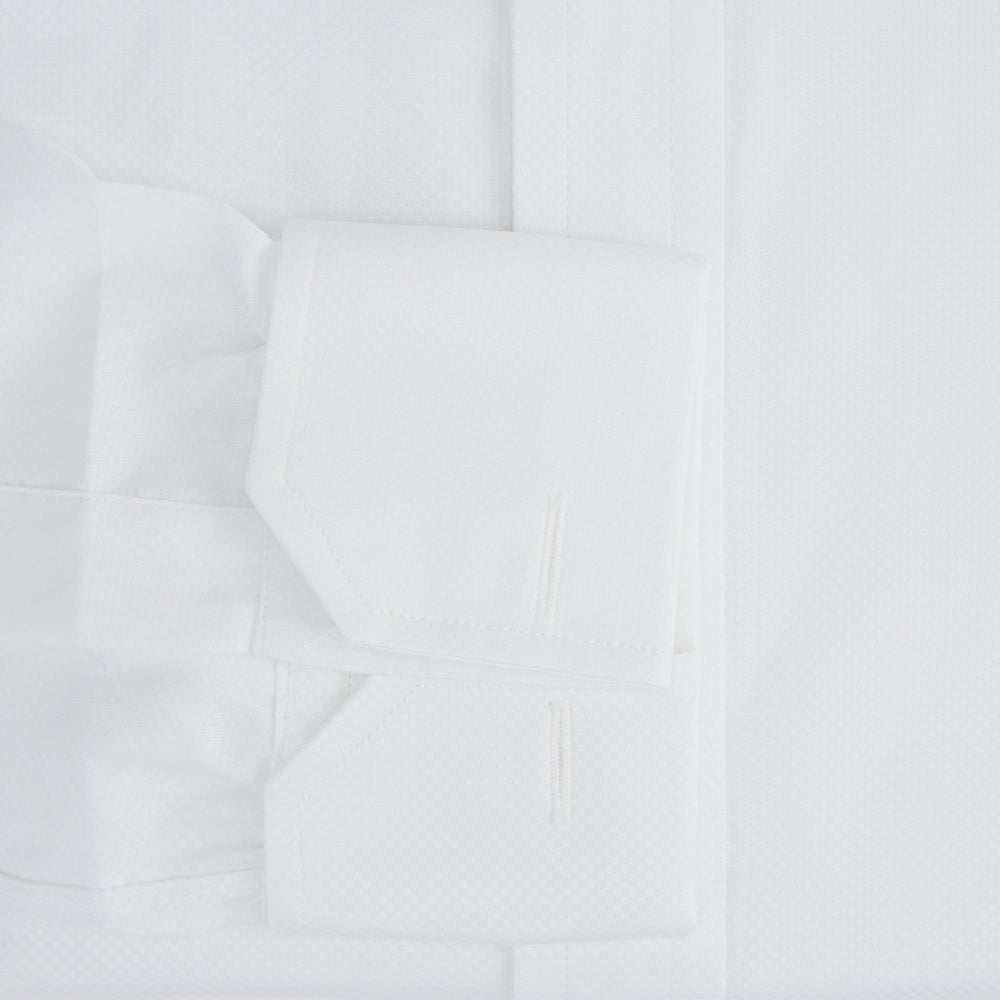 The Turnbull & Asser Casino Royale White Dress Shirt, as seen on James Bond, features long sleeves, a button-down front, and classic collar and cuffs. Displayed against a plain white background.