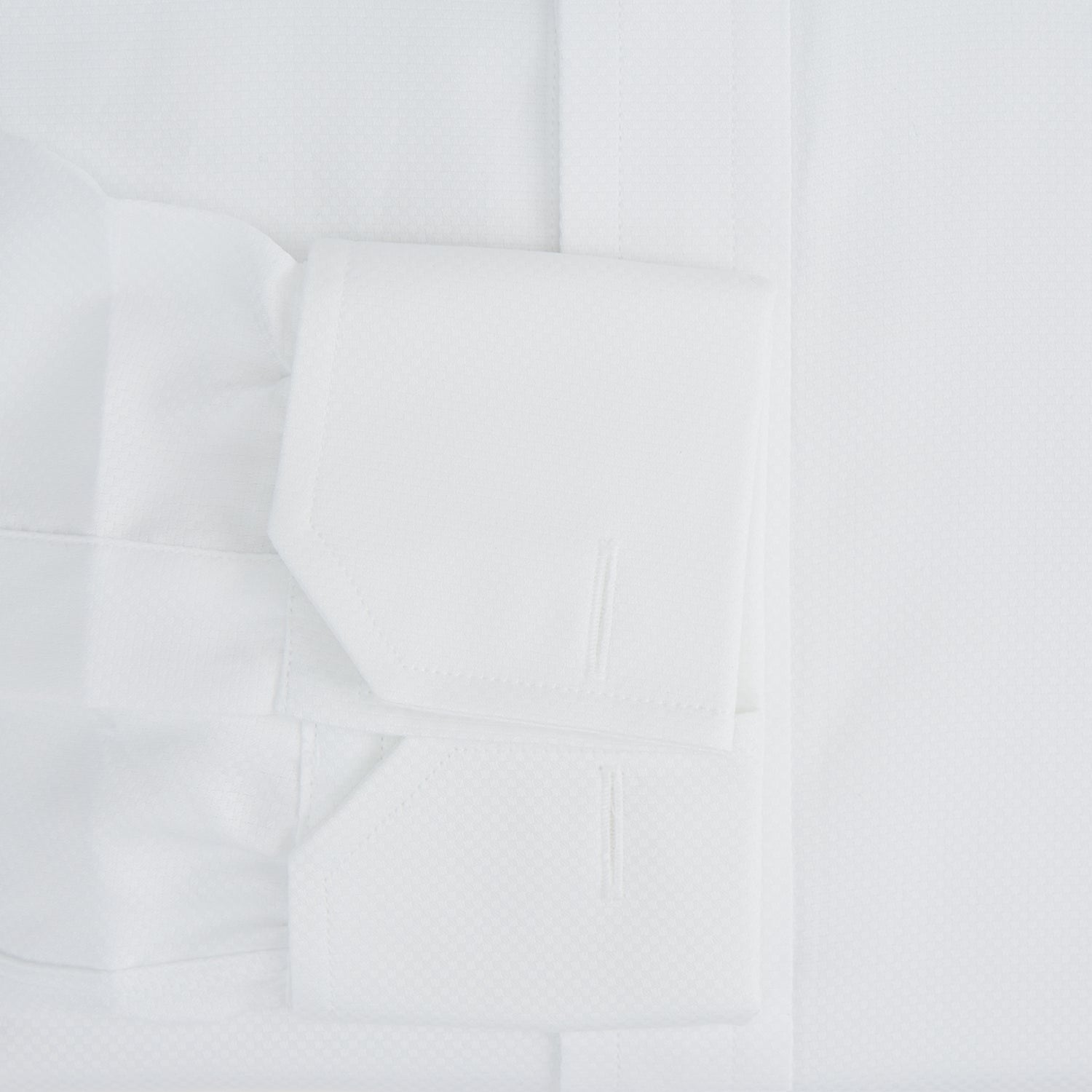 View 4 of product The Turnbull & Asser Casino Royale White Dress Shirt, as seen on James Bond, features long sleeves, a button-down front, and classic collar and cuffs. Displayed against a plain white background.