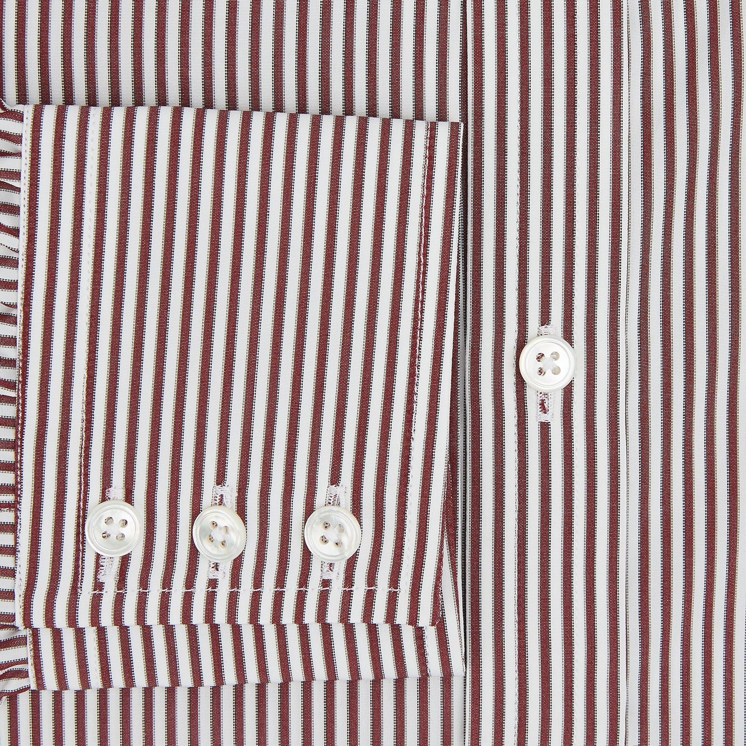 View 4 of product The Turnbull & Asser Burgundy Halo Stripe Winston Shirt features long sleeves, a classic T&A collar, buttoned cuffs, narrow vertical burgundy and white stripes, and is crafted from organic cotton. Displayed on a white background.