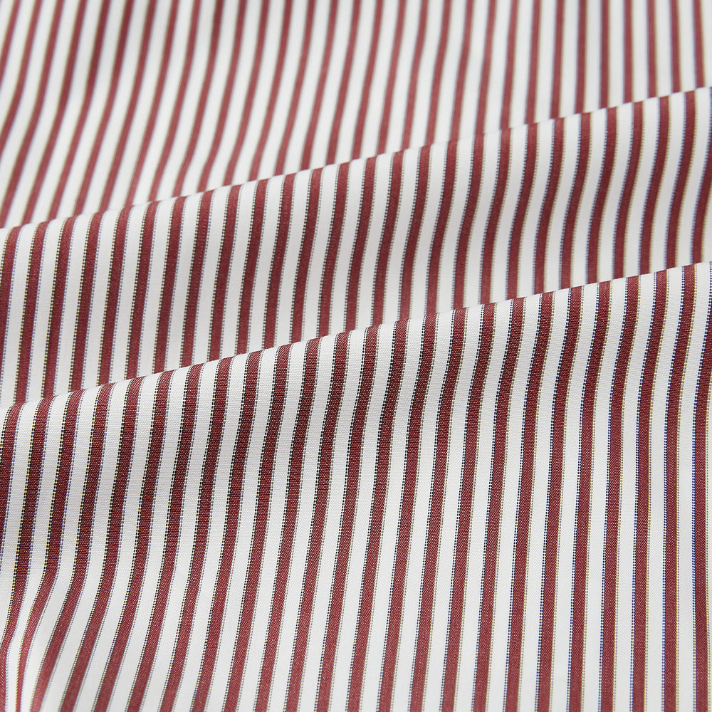 The Turnbull & Asser Burgundy Halo Stripe Winston Shirt features long sleeves, a classic T&A collar, buttoned cuffs, narrow vertical burgundy and white stripes, and is crafted from organic cotton. Displayed on a white background.