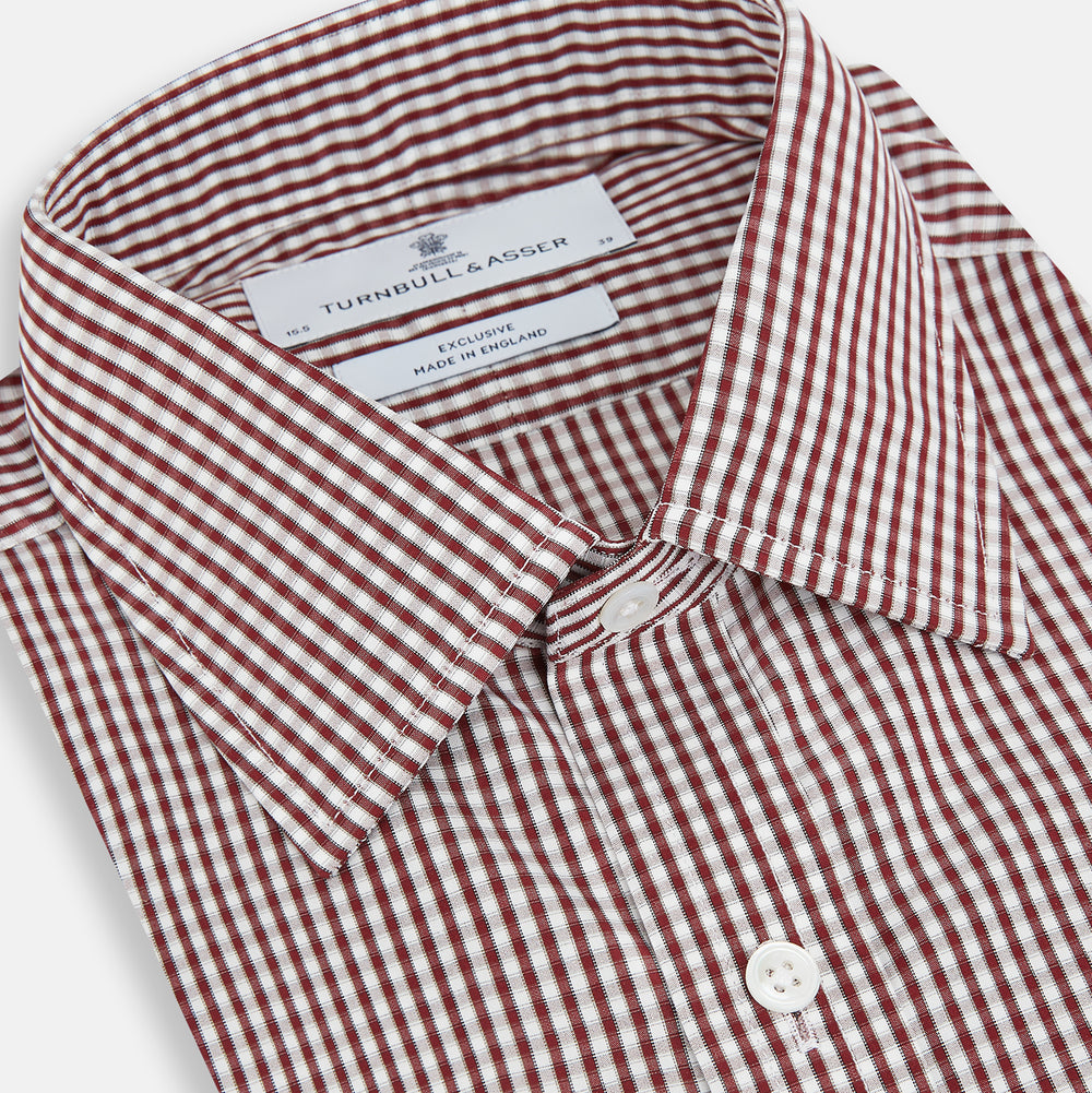 The Turnbull & Asser Burgundy Micro Check Winston Shirt is a long-sleeved, button-up Mayfair fit dress shirt with a collar and buttoned cuffs, featuring a small red and white check pattern and shown on a white background.