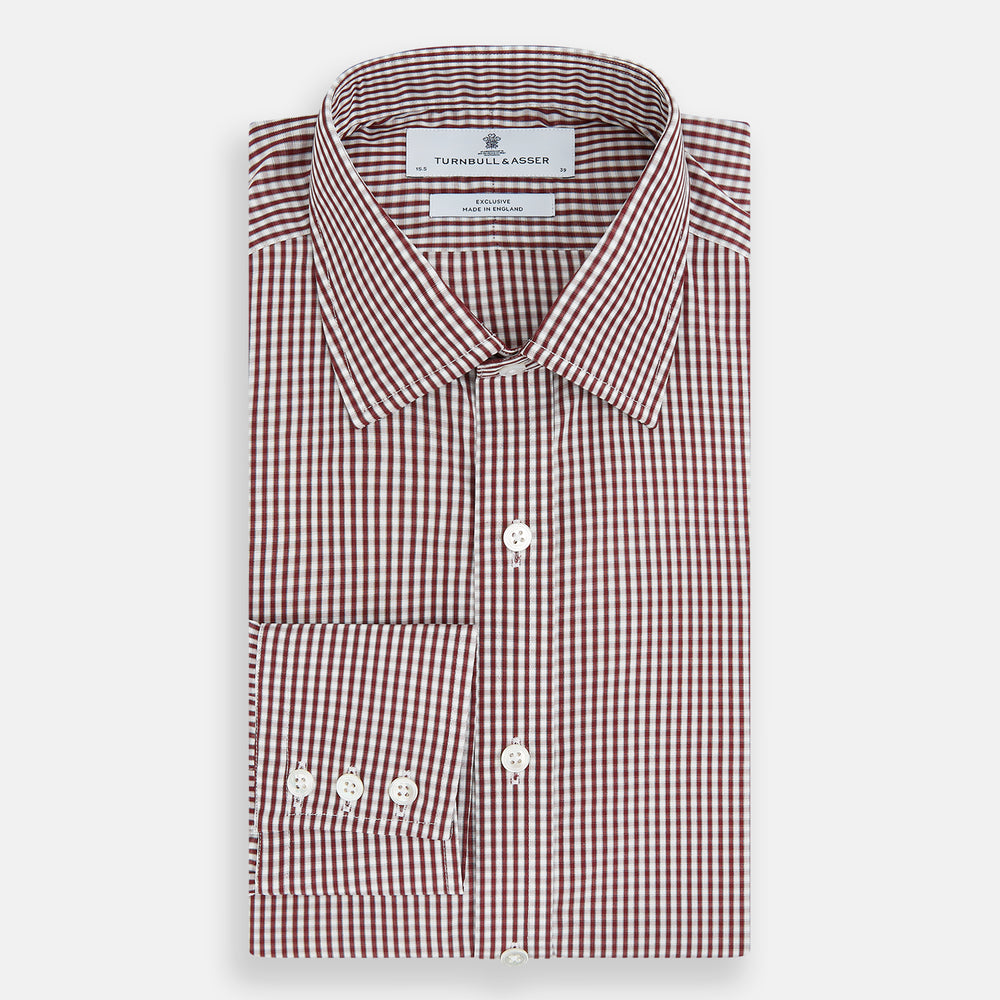 The Turnbull & Asser Burgundy Micro Check Winston Shirt is a long-sleeved, button-up Mayfair fit dress shirt with a collar and buttoned cuffs, featuring a small red and white check pattern and shown on a white background.