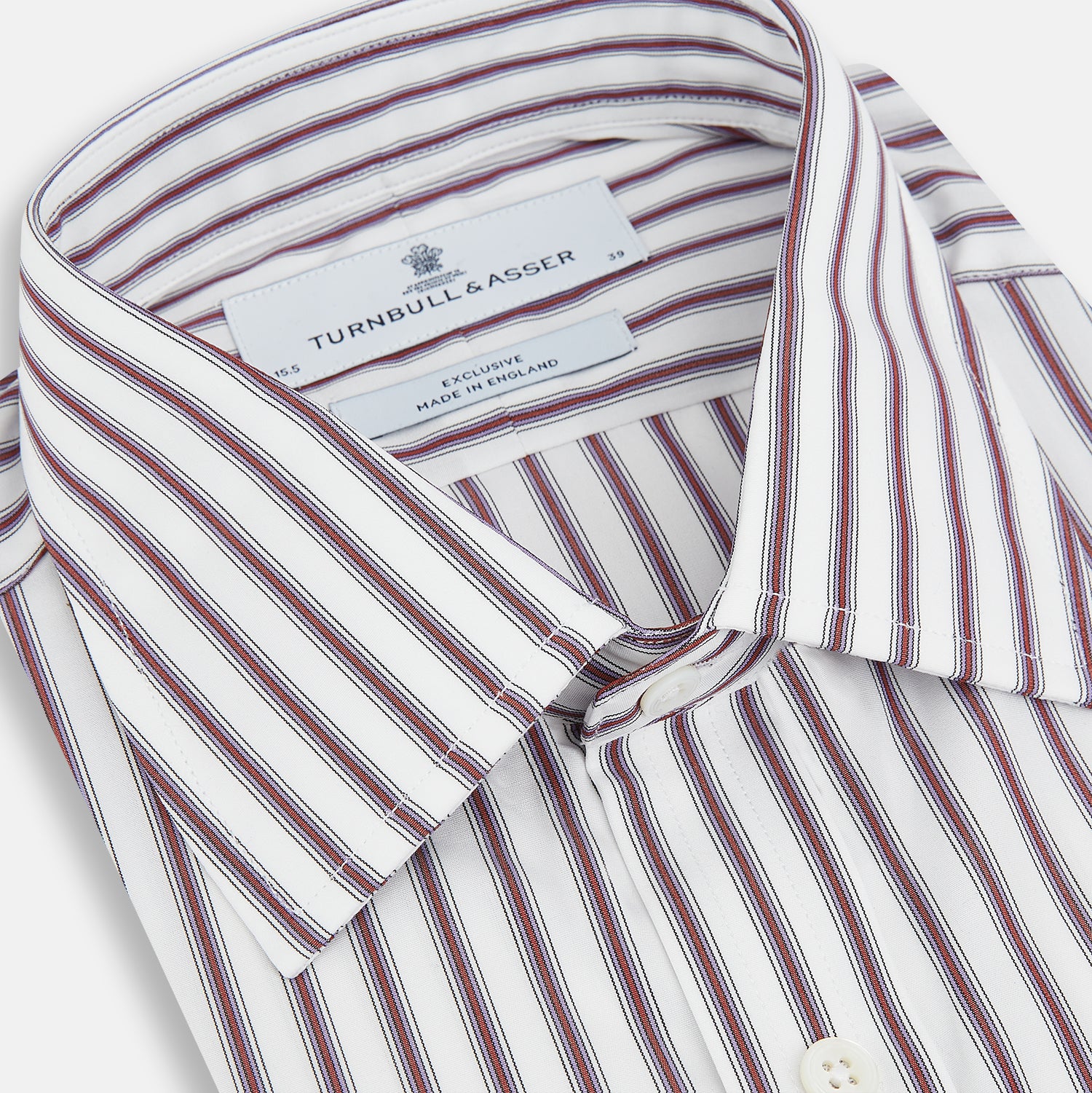 View 2 of product The Turnbull & Asser Burgundy Track Stripe Winston Shirt features long sleeves, classic collar, buttoned cuffs, and vertical white and dark maroon stripes—perfect for formal wear and shown laid flat against a white background.
