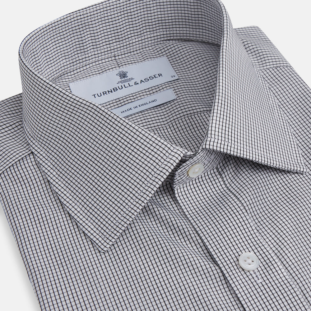 The Turnbull & Asser Dark Blue and White Graph Check Mayfair Shirt is a long-sleeve, button-up shirt with a pointed collar, shown on a plain white background.