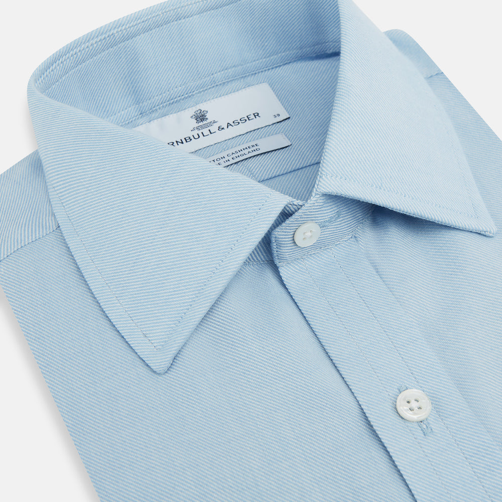 The Turnbull & Asser Blue Cotton Cashmere Mayfair Shirt features long sleeves, a classic collar, buttoned cuffs, and white buttons, shown against a white background.